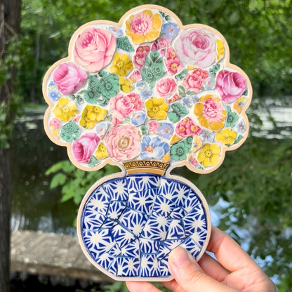A charming floral mosaic using a curated collection of vintage china patterns set inside a custom bouquet-in-a-vase wooden frame.