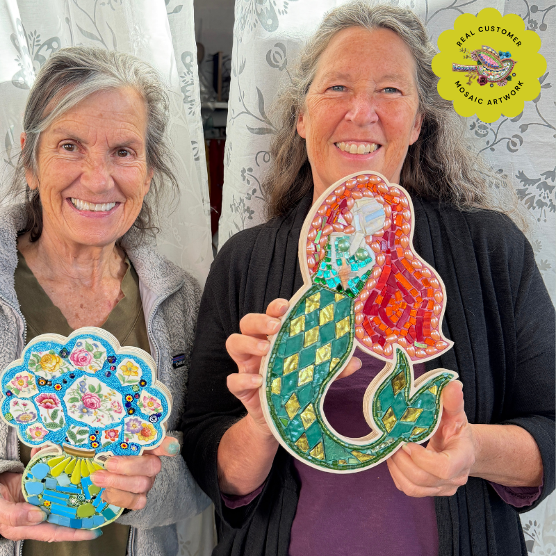 Two mosaic class students holding mosaic art pieces made in wooden mosaic frames.