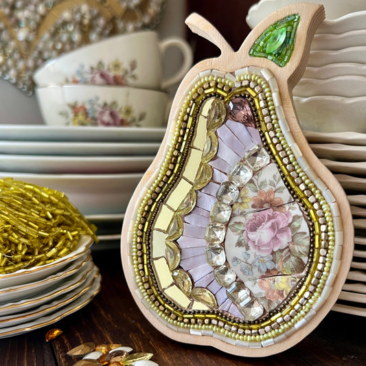 Decorative pear-shaped mosaic with in a wooden frame made with china, beads and rhinestones.