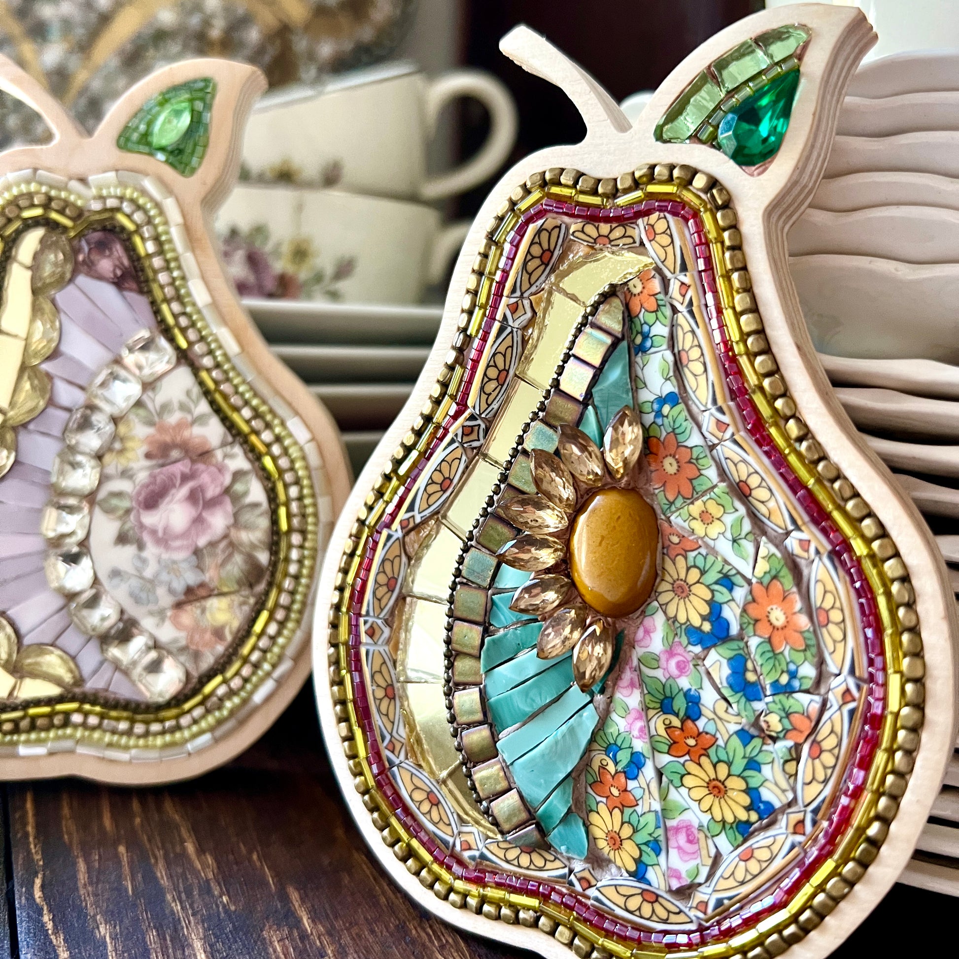 Decorative pear-shaped mosaic with in a wooden frame made with china, beads and rhinestones.