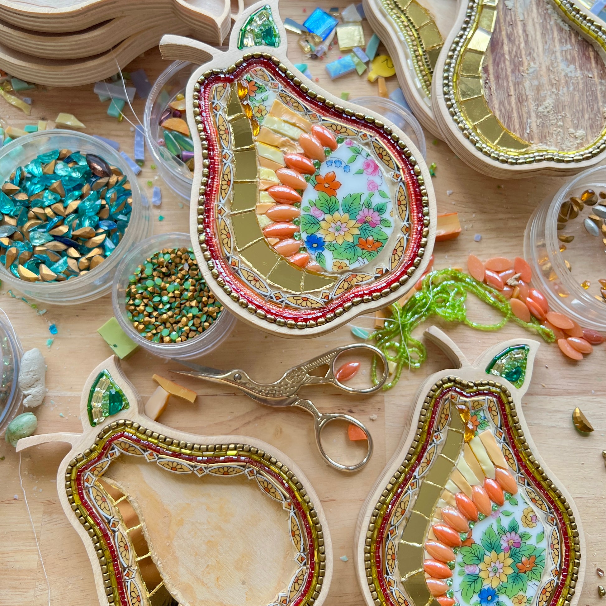 Decorative pear-shaped mosaic with in a wooden frame made with china, beads and rhinestones.