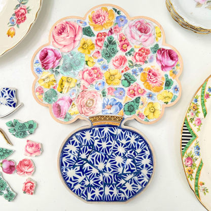 A charming floral mosaic using a curated collection of vintage china patterns set inside a custom bouquet-in-a-vase wooden frame.