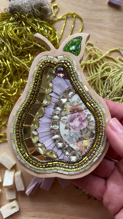 Decorative pear-shaped mosaic with in a wooden frame made with china, beads and rhinestones.