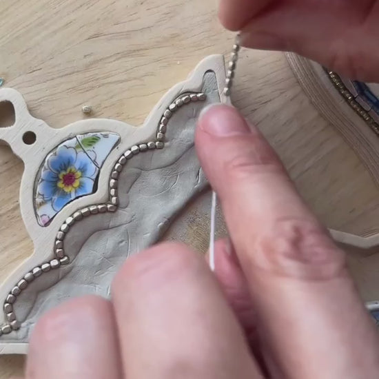 Mosaic Artist Sharra Frank making a teapot mosaic with beads, china and glass.
