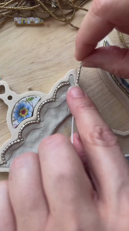 Mosaic Artist Sharra Frank making a teapot mosaic with beads, china and glass.